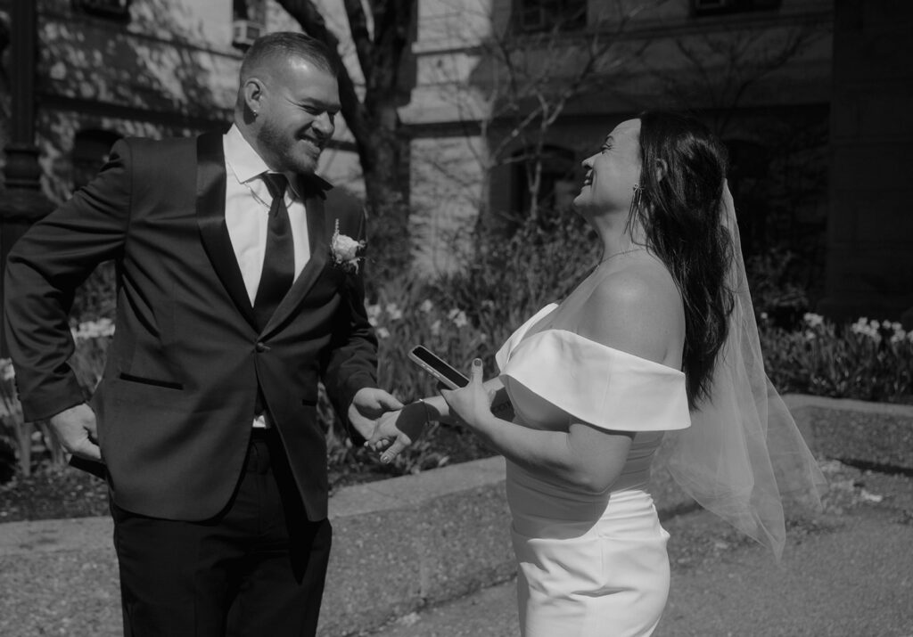 Black and white photo of a bride and groom exchanging private vows in the courtyard during their Philadelphia City Hall wedding photos