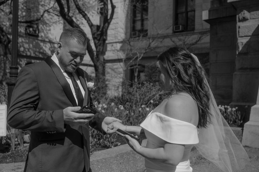 Black and white photo of a bride and groom exchanging private vows in the courtyard during their Philadelphia City Hall wedding photos