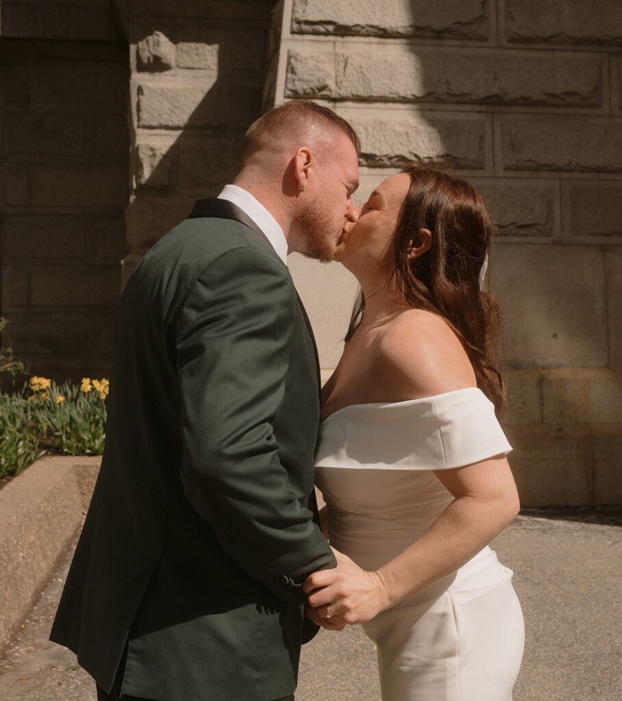 Bride and groom kissing after private vows in the courtyard of Philadelphia City Hall