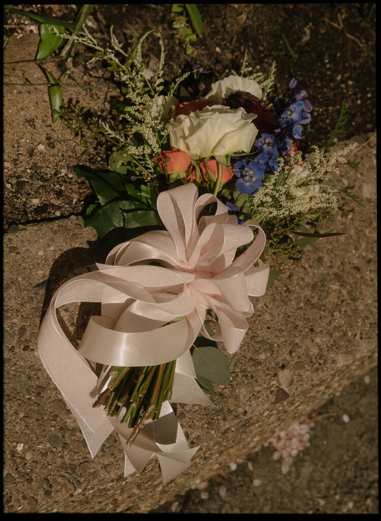 Brides wedding bouquet on the ground during private vows in the courtyard of Philadelphia City Hall