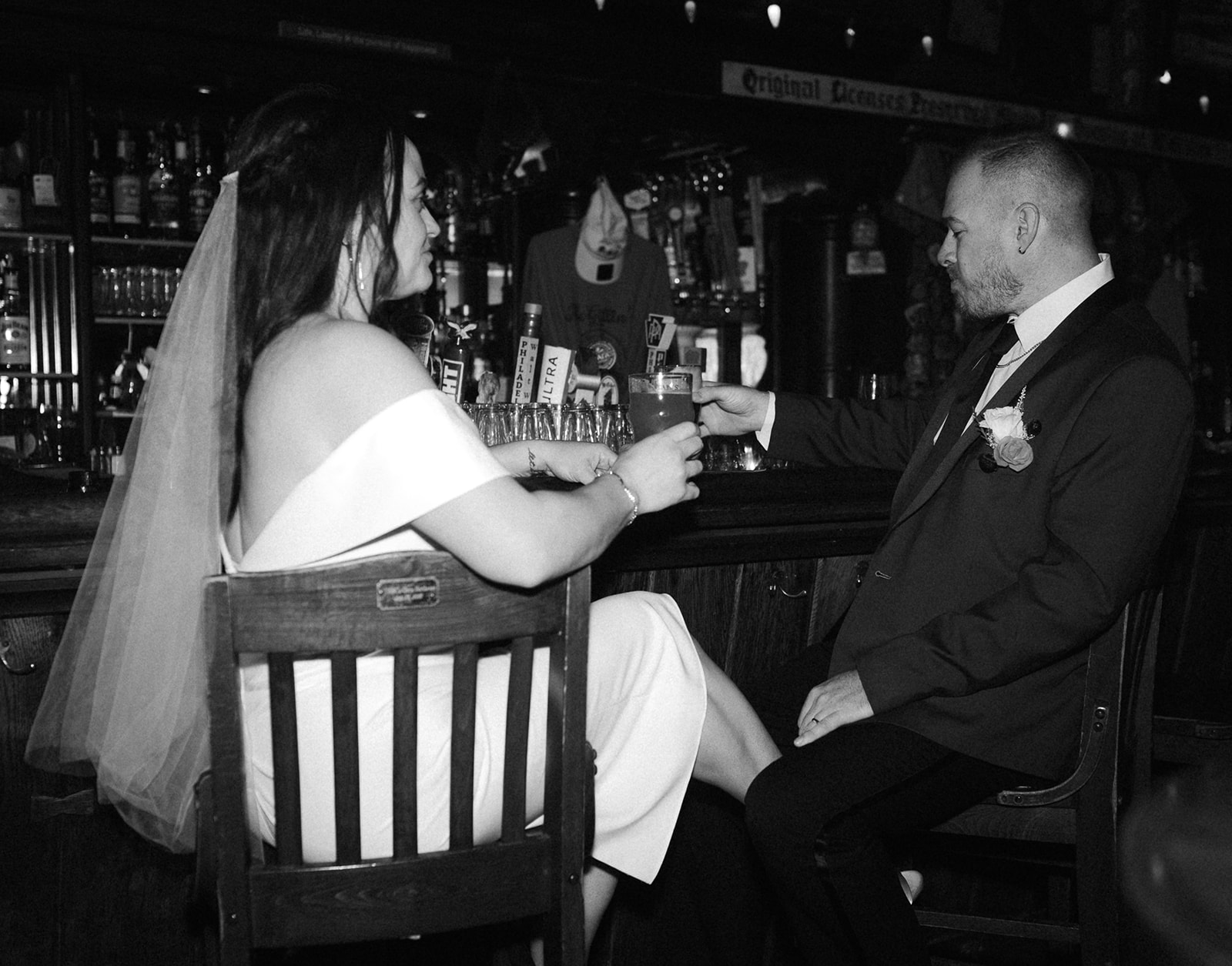 Black and white photo of a bride and groom having drinks McGillin's Ole Ale House after their Philadelphia elopement