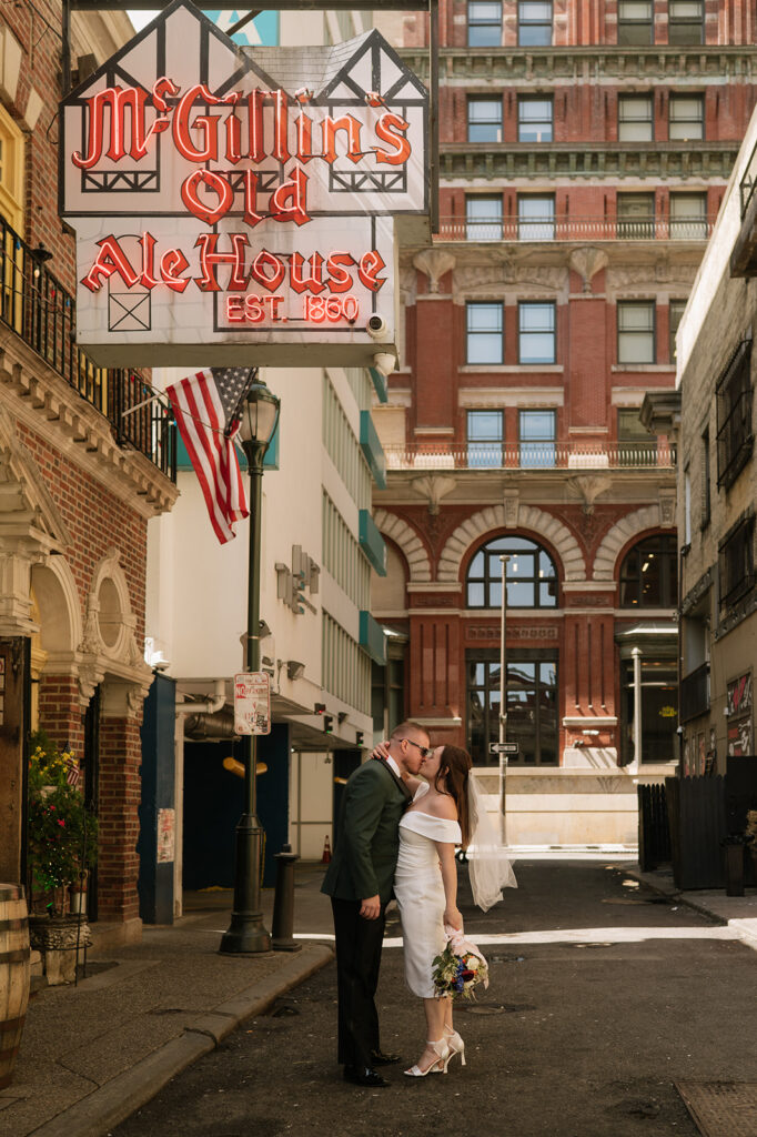 Bride and groom kissing outside of McGillin's Ole Ale House for their Philadelphia elopement photos