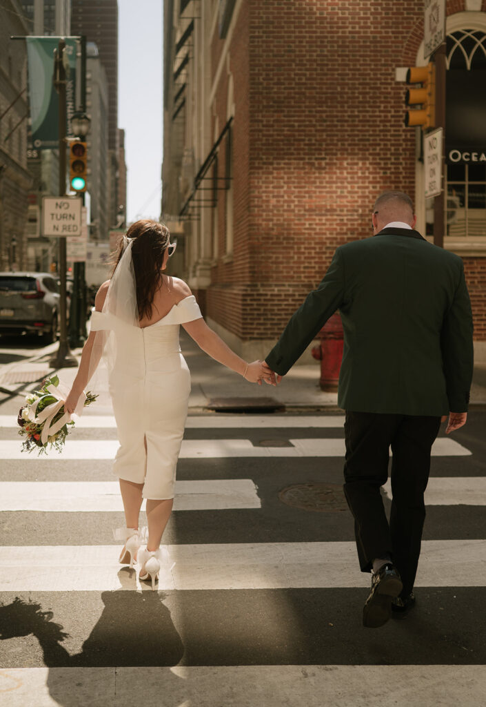 Couple holding hands and walking downtown for their Philadelphia elopement photos