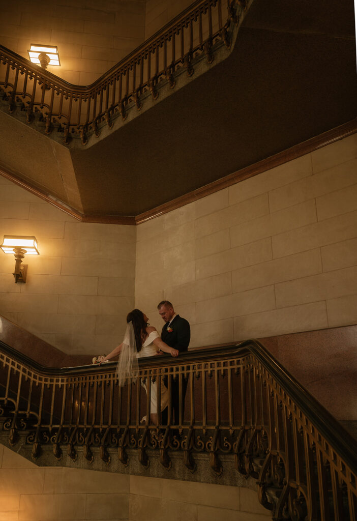 Bride and groom posing on the staircase for their Philadelphia City Hall wedding photos