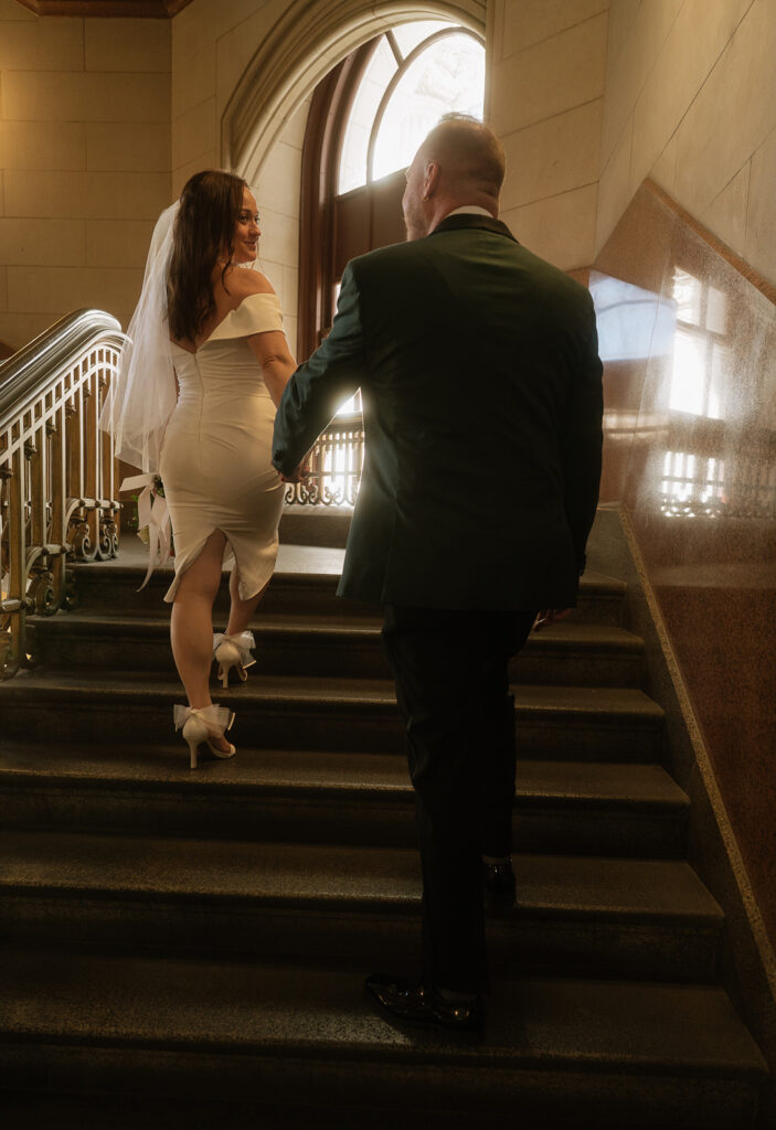 Bride and groom walking up the staircase for their Philadelphia City Hall wedding