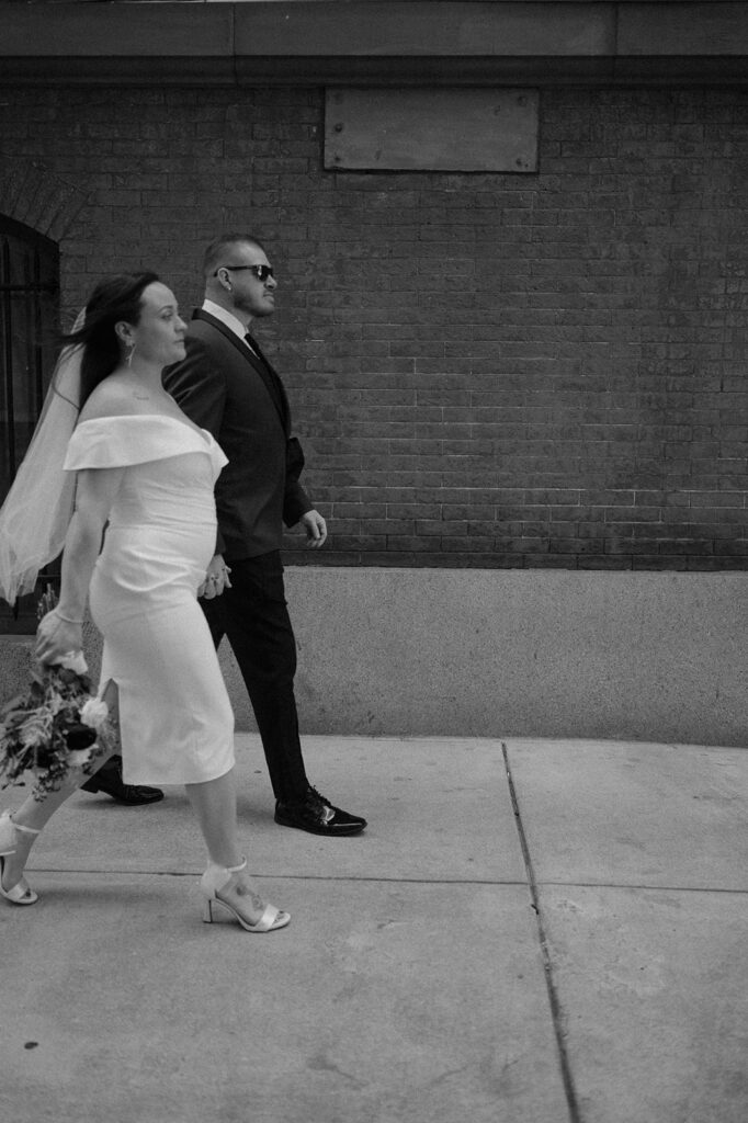 Black and white photo of a bride and groom walking downtown for their Philadelphia elopement photos