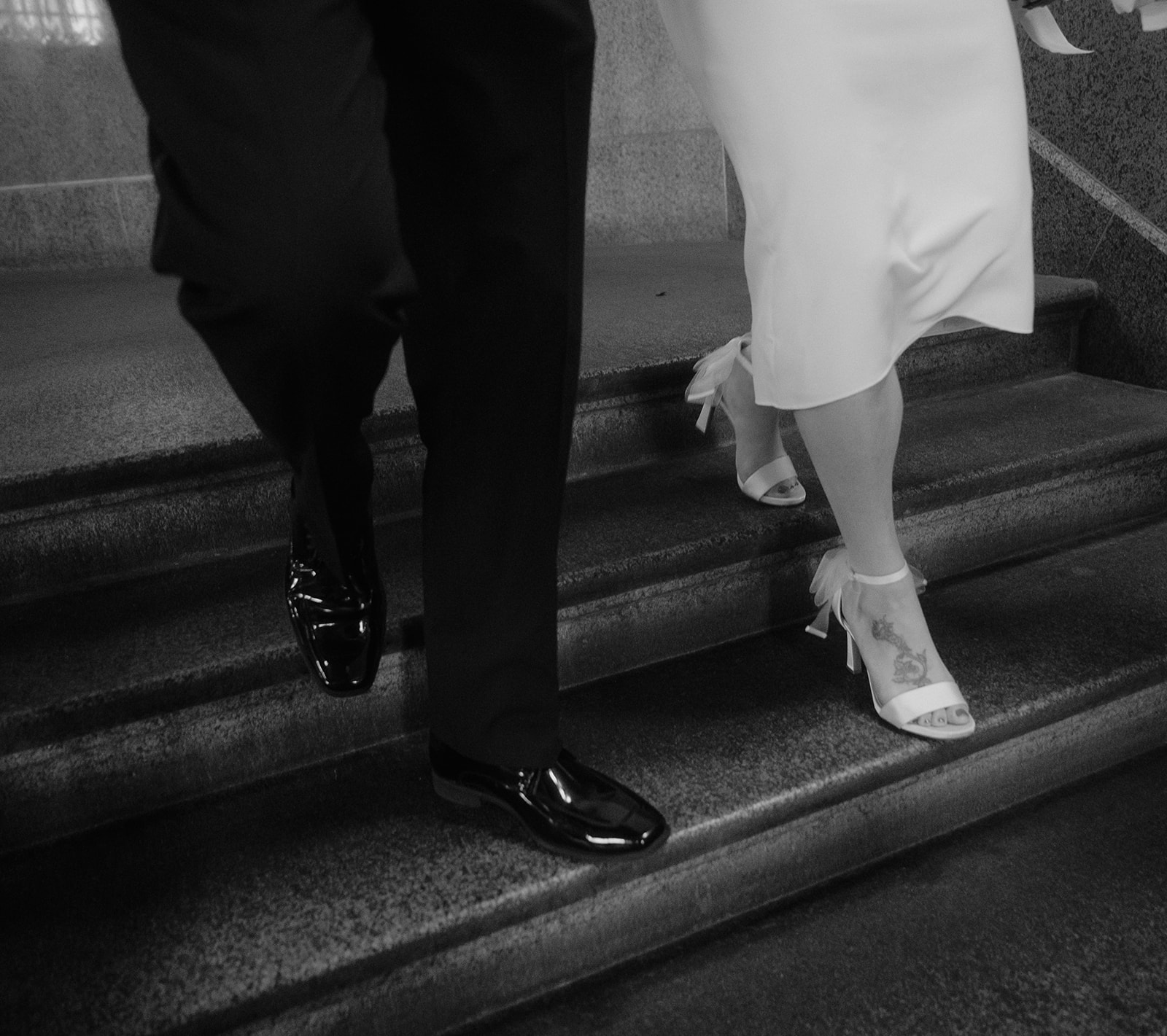 Black and white close up shot of a bride and groom walking down the stairs at Philadelphia City Hall