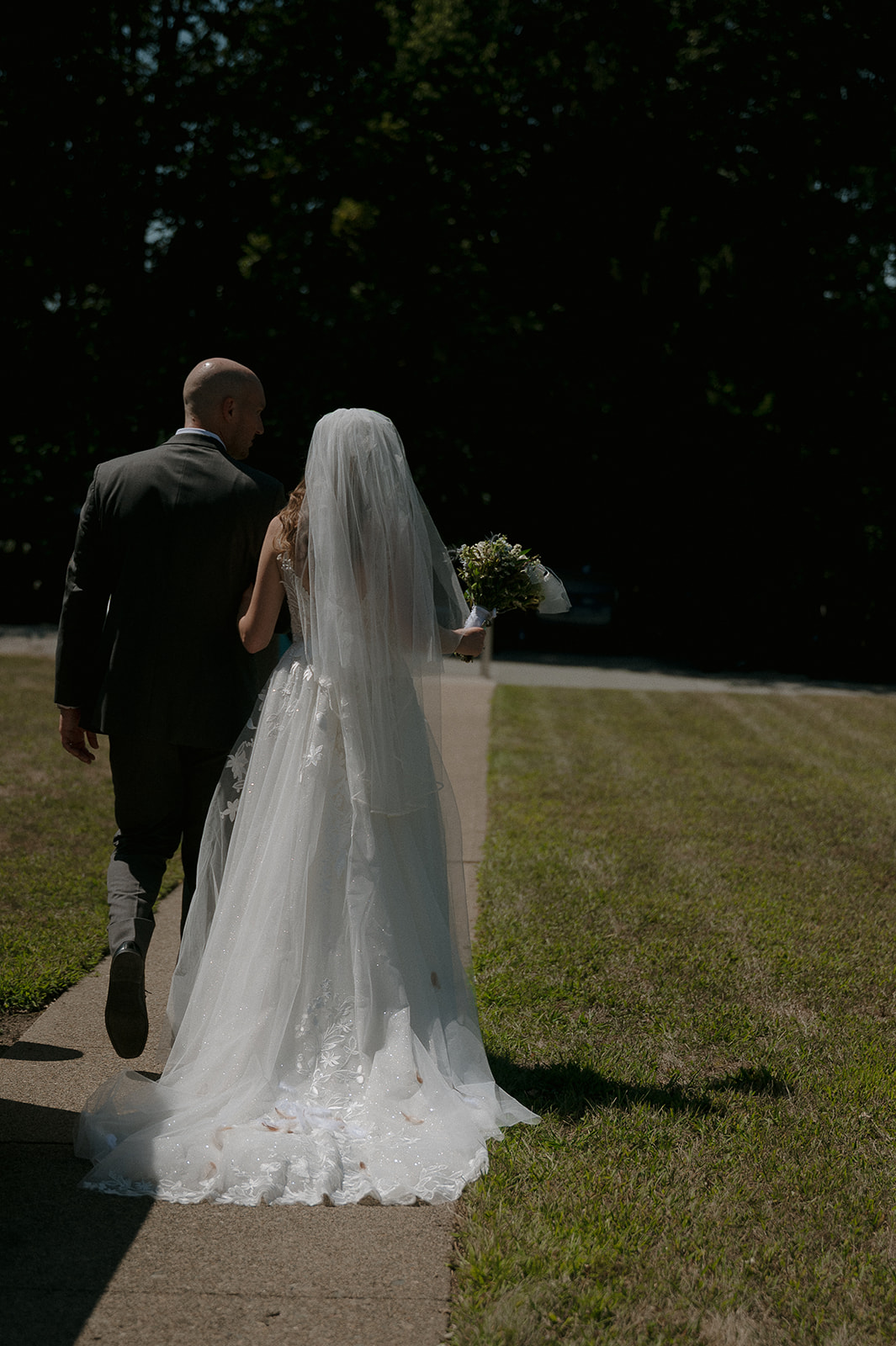 Candid photo of a bride walking away from the church as husband and wife