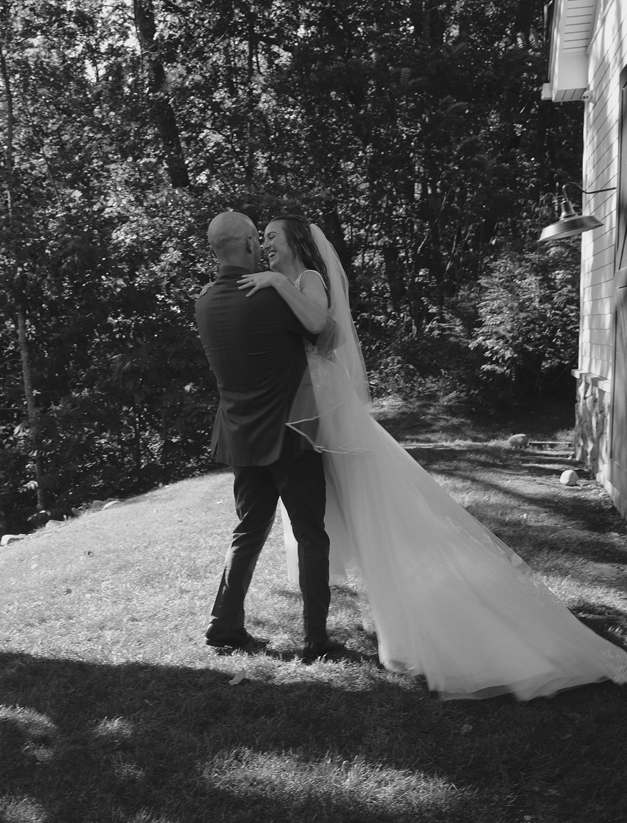 Bride lifting and twirling his bride during their The Inn at Millrace Pond wedding portraits