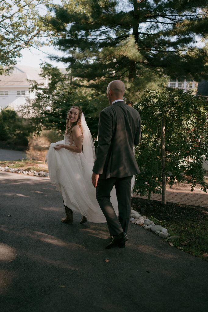 Candid photo of a bride and groom walking at The Inn at Millrace Pond wedding venue