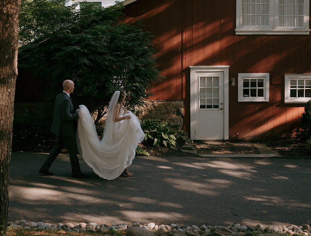 Storytelling wedding photography of a couple walking outside of The Inn at Millrace Pond wedding venue