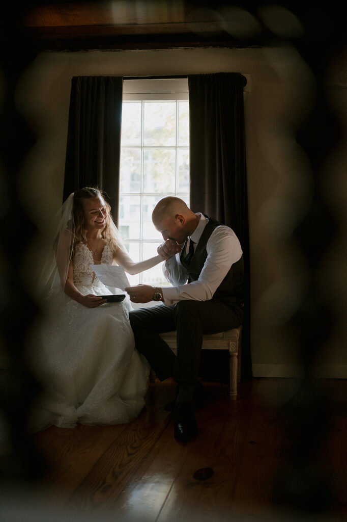 Bride and groom sharing private vows to one another as the groom kisses her hand - storytelling wedding photography