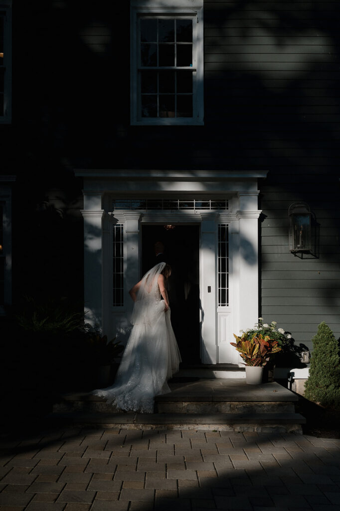 Bride walking into house at The Inn at Millrace Pond