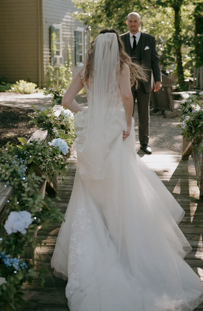 Bride running over a small bridge to the groom at The Inn at Millrace Pond wedding venue