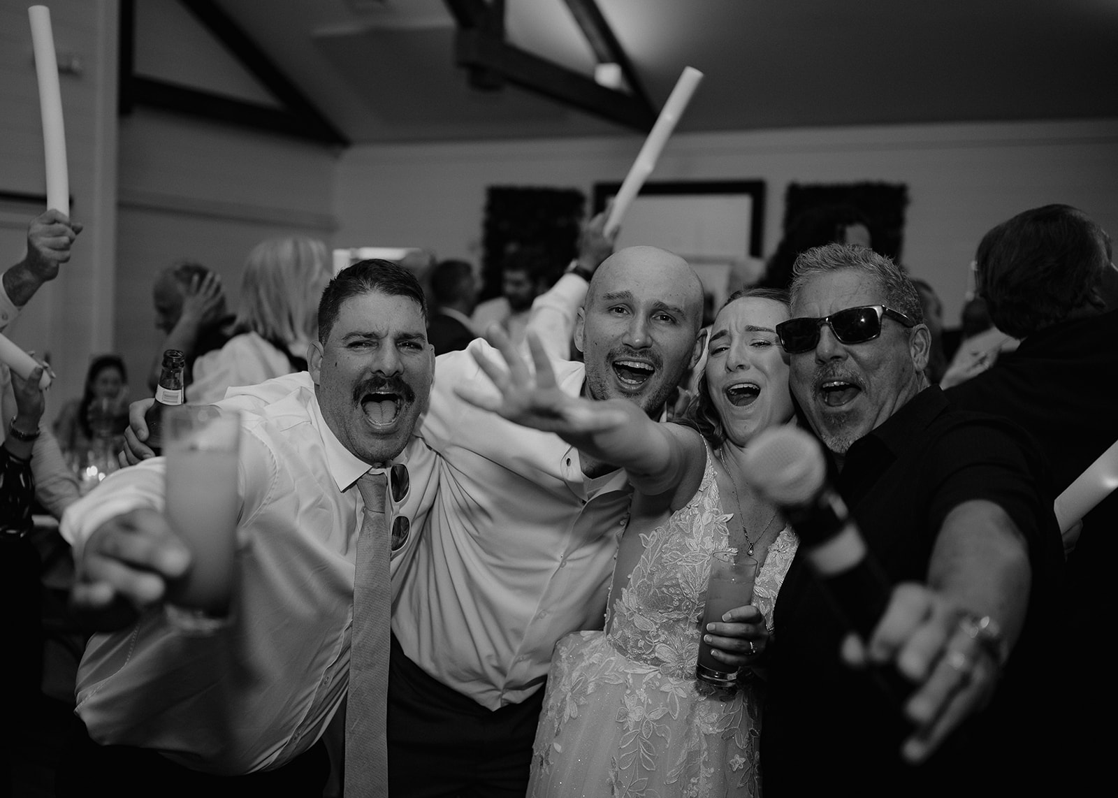 Bride, groom, and wedding guests dancing and singing during The Inn at Millrace Pond wedding reception