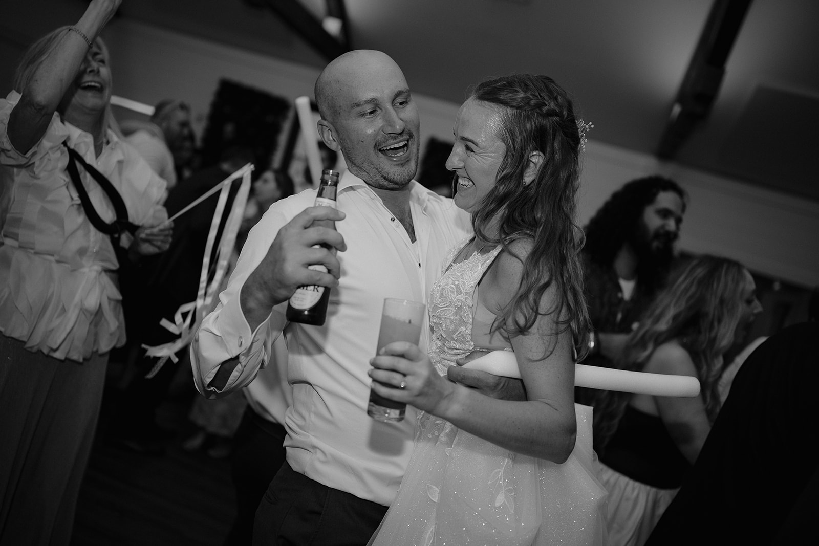 Candid black and white photo of a bride and groom dancing during their reception