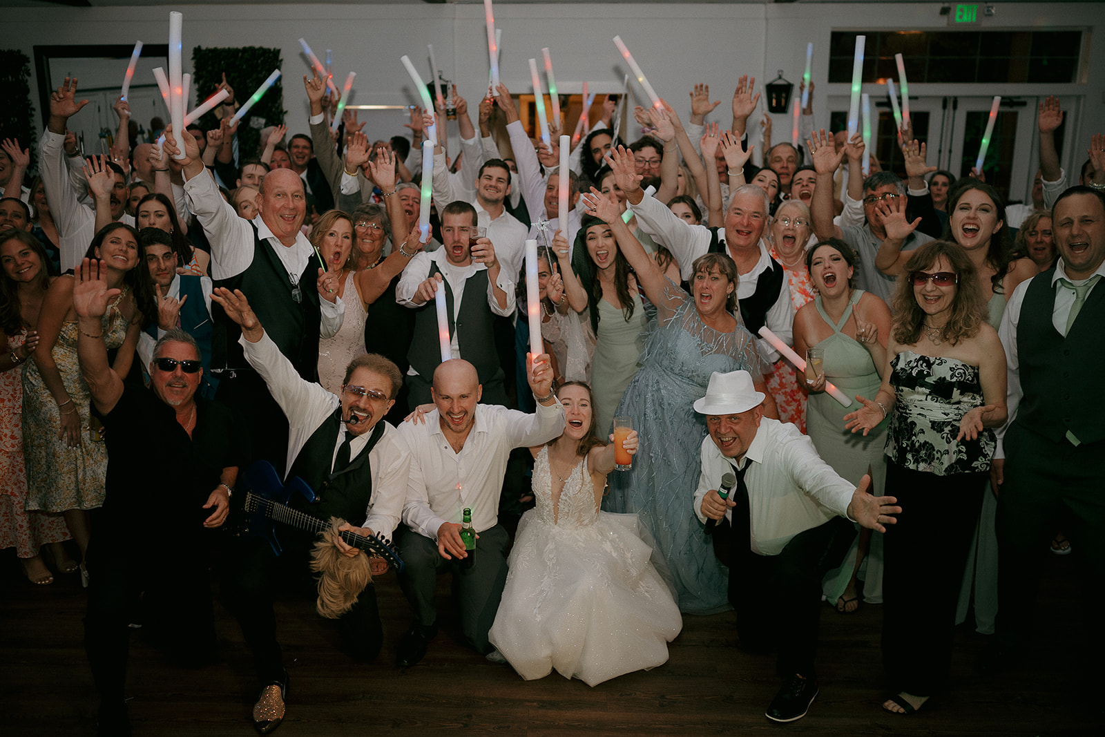 Bride and groom posing with a large group of their guests