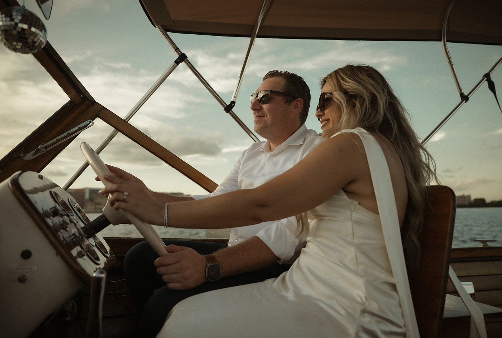 Couple steering The Argonaut together during their romantic engagement session on the water in Philadelphia.