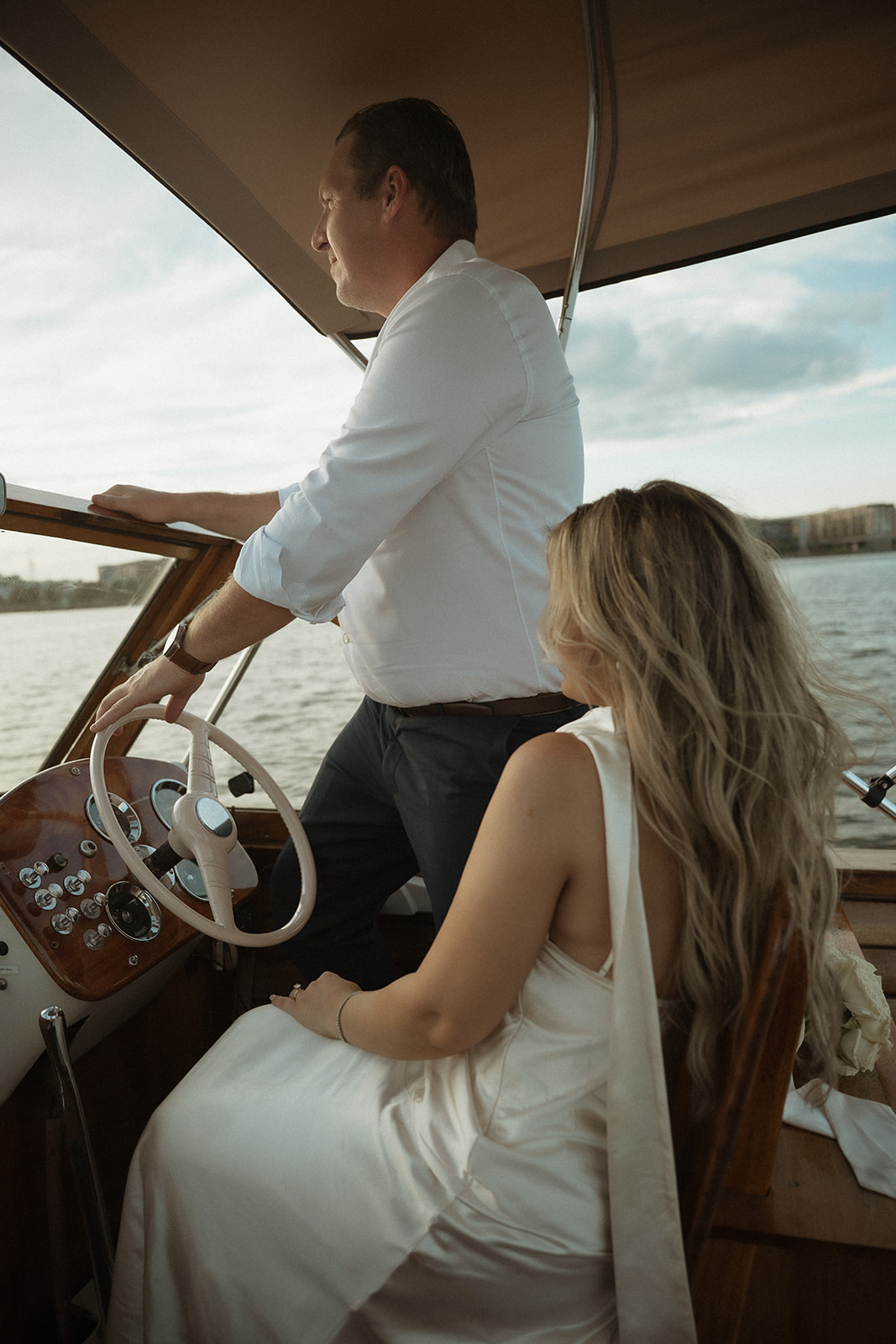 Couple steering the Argonaut with Sea Philly during a golden sunset engagement session on the water.