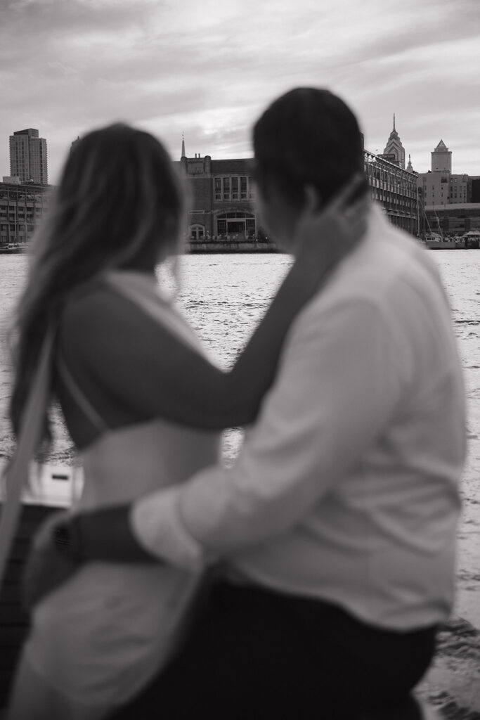 Black and white photo of Nicole and Chris looking out at the water during their romantic Sea Philly engagement session in Philadelphia.