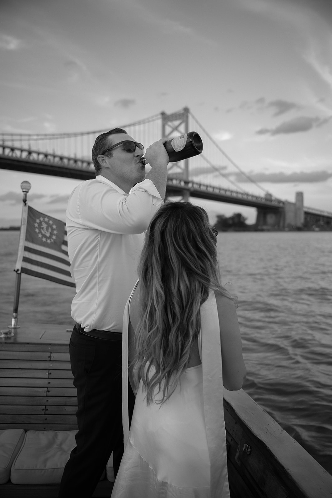 Black and white photo of a couple admiring the views during their Philly engagement photos on a boat