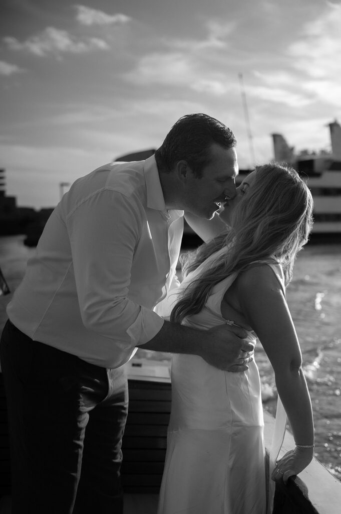 Black and white photo of a couple kissing on a boat
