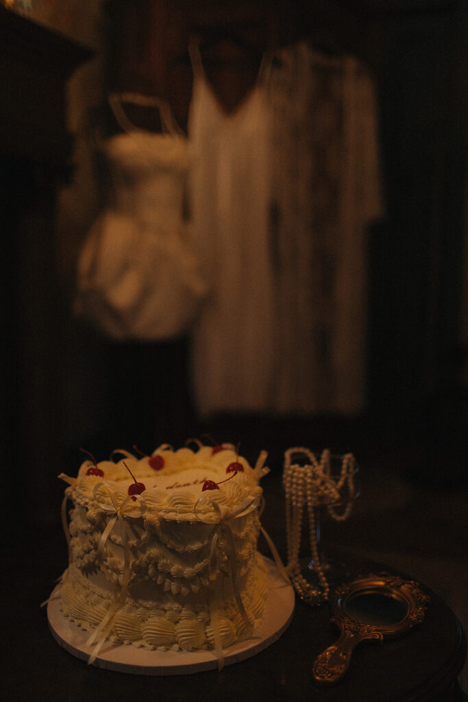 Close-up of vintage cake details, pearls, and an antique hand mirror — soft, romantic textures photographed during an intimate wedding session in Frenchtown, NJ.