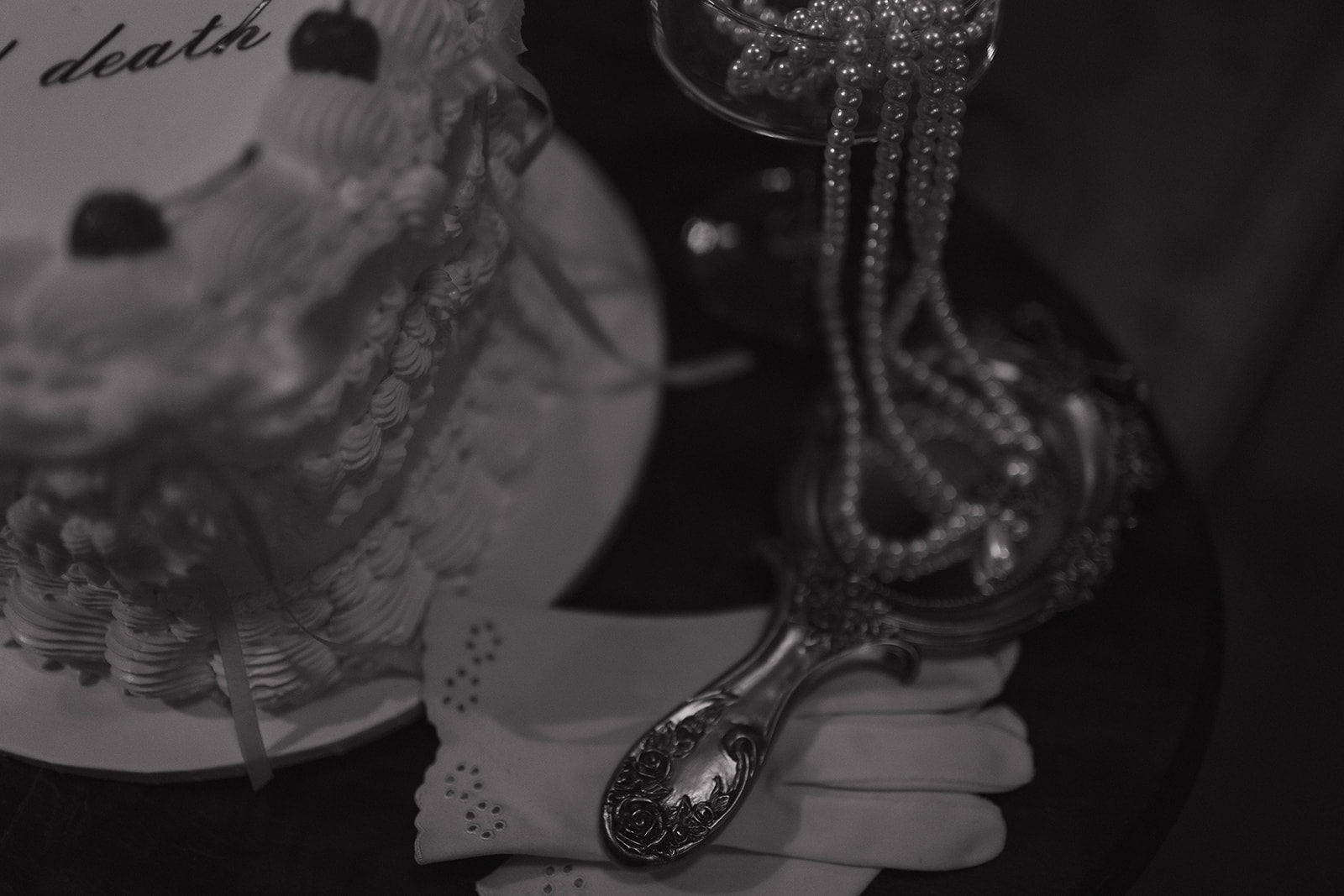 Close-up of vintage cake details, pearls, and an antique hand mirror — soft, romantic textures photographed during an intimate wedding session in Frenchtown, NJ.