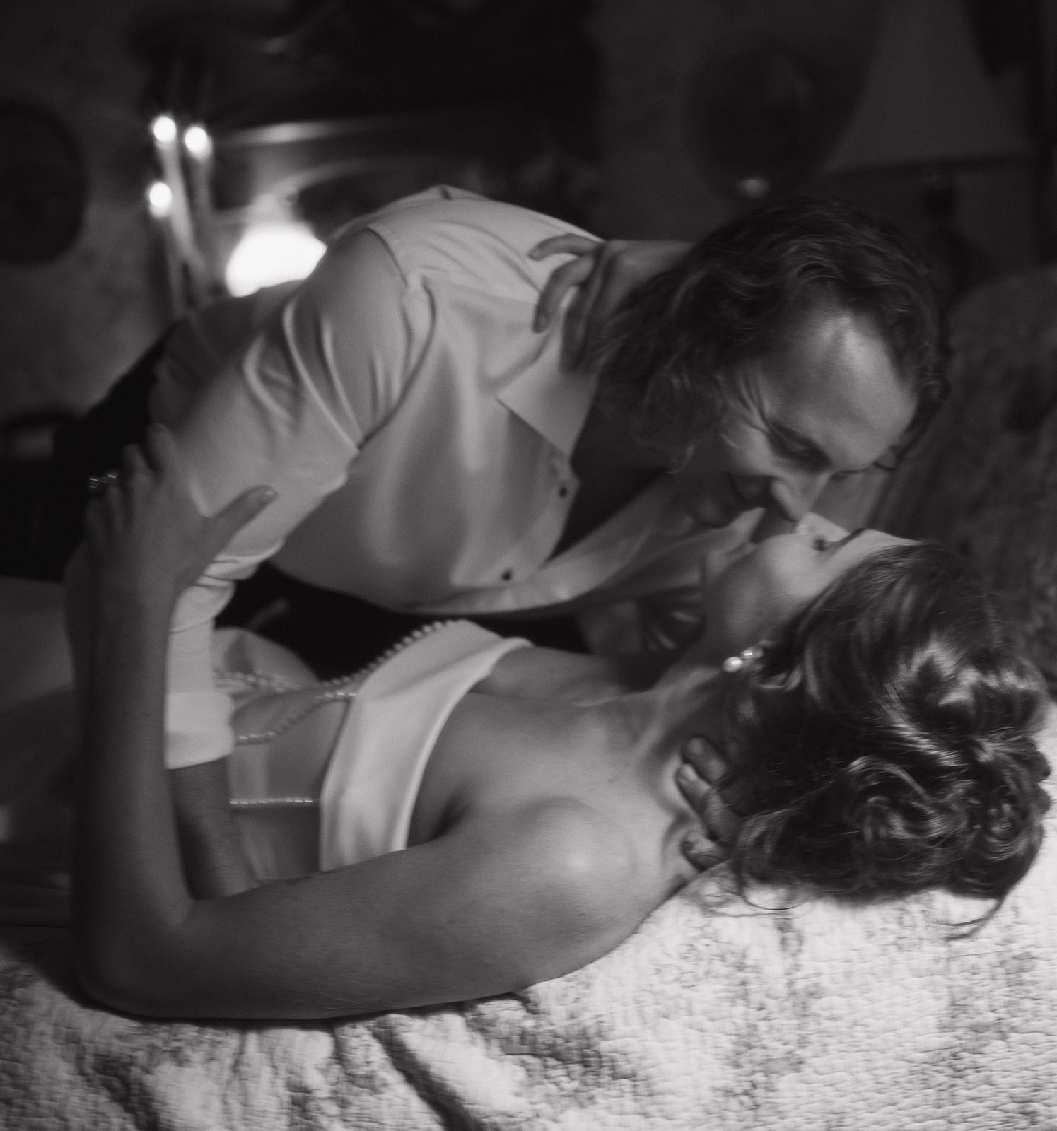 Black-and-white close-up of the couple kissing on the bed, creating a nostalgic, old-Hollywood feel for their intimate New Jersey wedding photos.