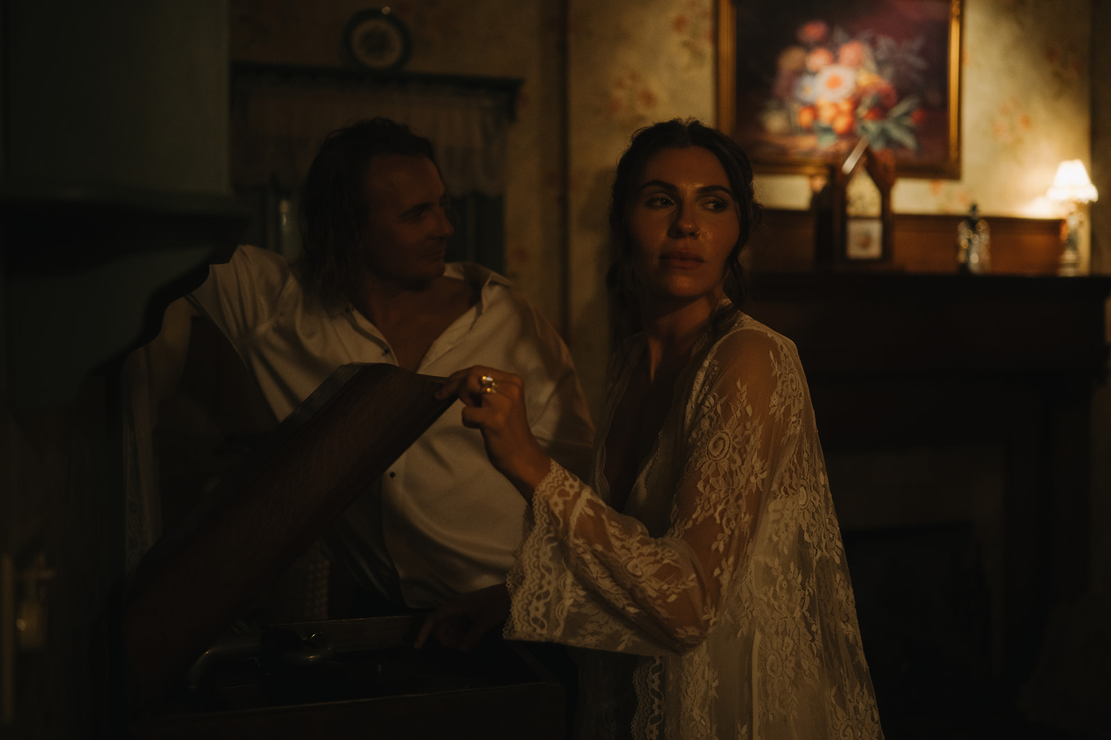 The bride turns on a vintage record player while the groom watches with a soft smile, creating a nostalgic and romantic moment captured by New Jersey wedding photographer Ell Peters.