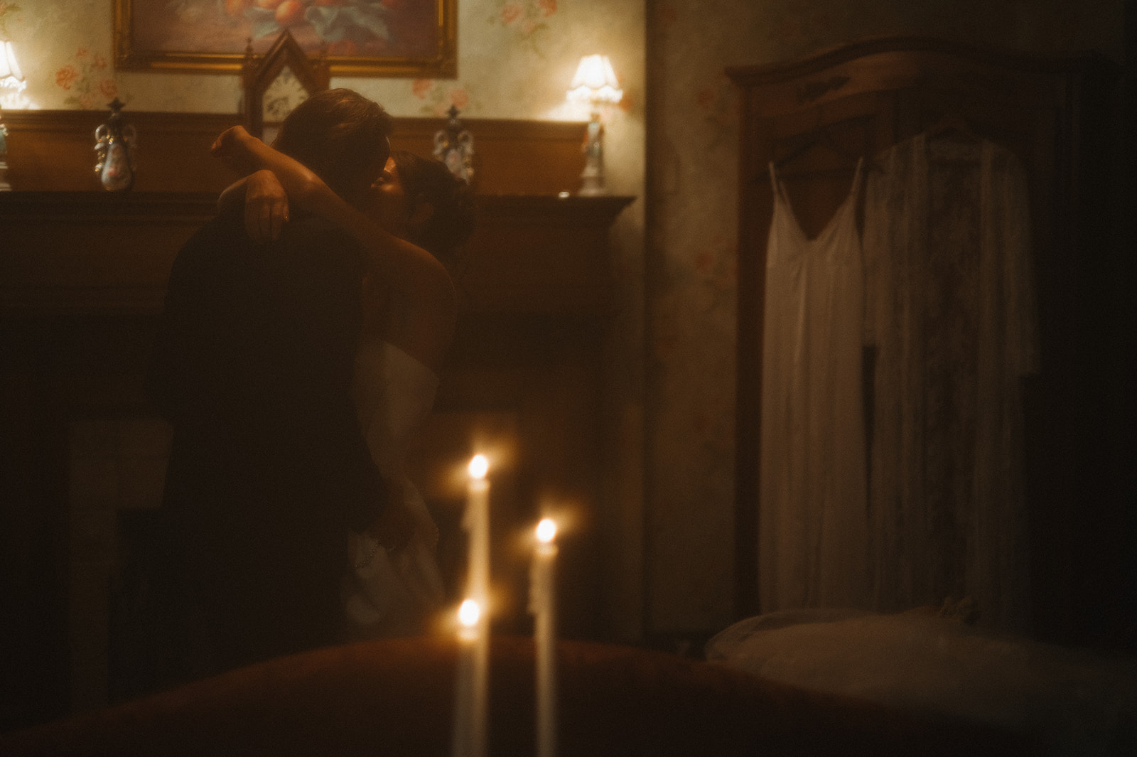 Soft, candlelit moment of the couple embracing beside the fireplace in the cottage — a cinematic take on intimate wedding photos in New Jersey.