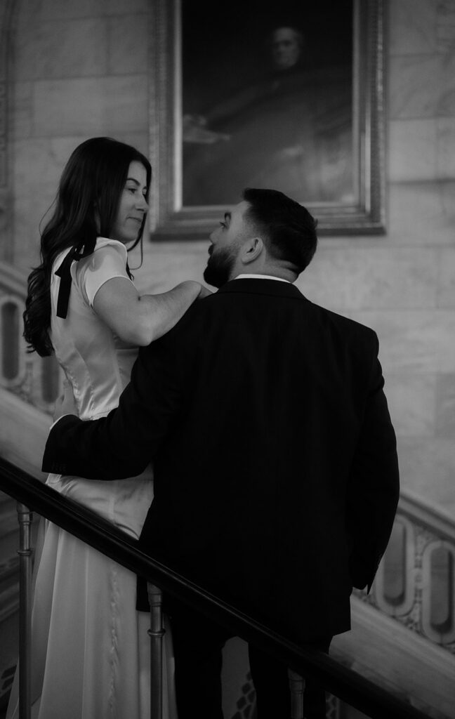Couple posing on the staircase for their New York Public Library engagement photos.