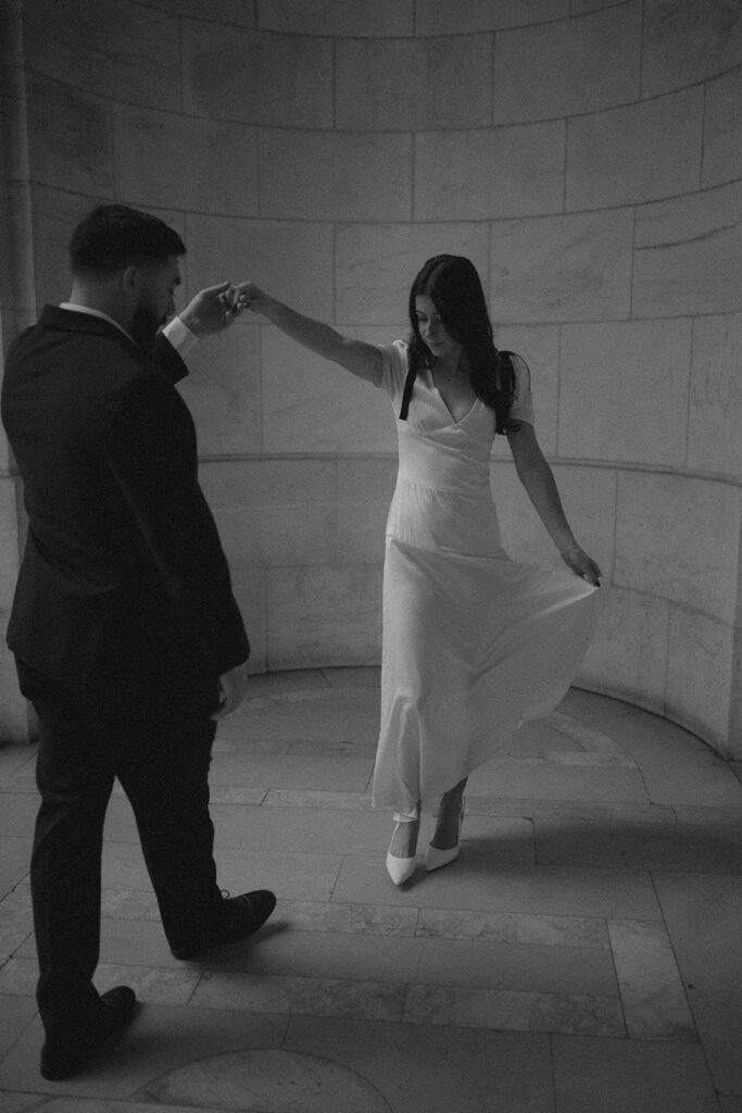 Black and white photo of a couple dancing during their romantic engagement session.