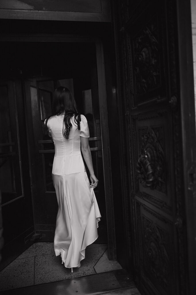 Black and white photo of a couple walking through a doorway.