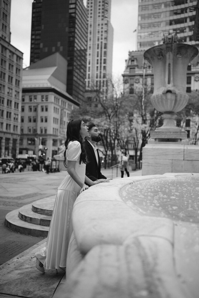 Couple admiring the statues outside during their their New York Public Library engagement photos.