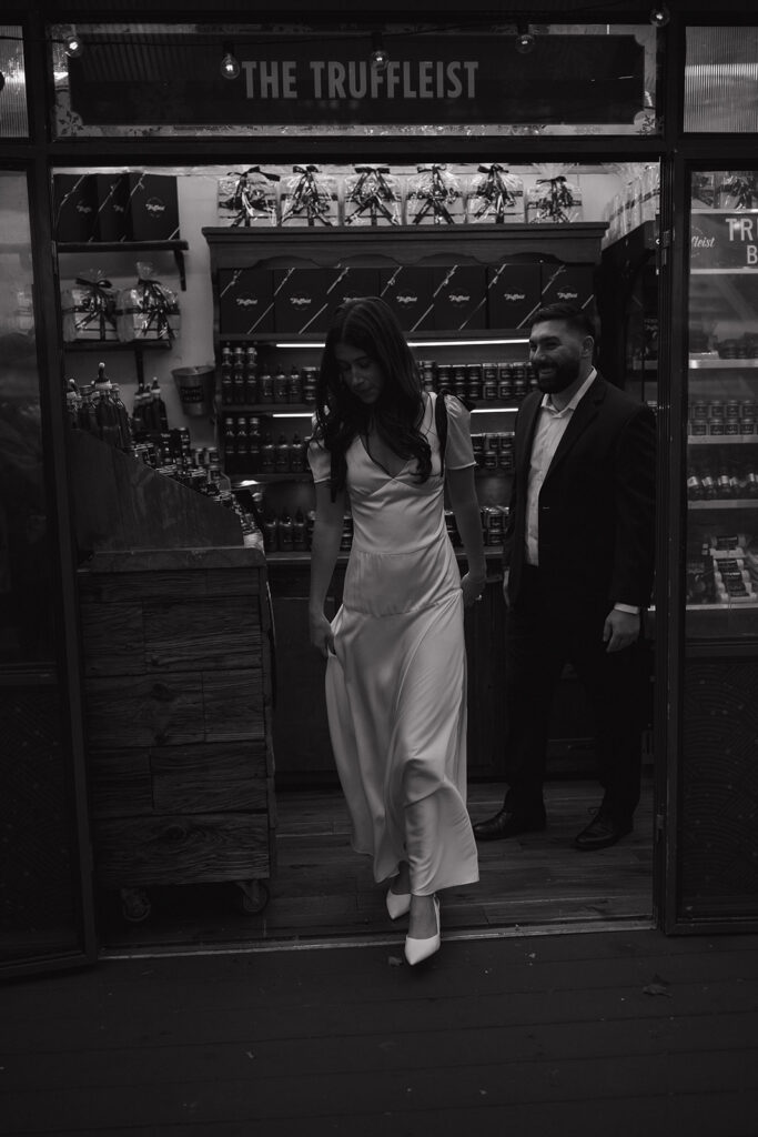 Black and white photo of a couple walking out of The Truffelist in Bryant Park. 
