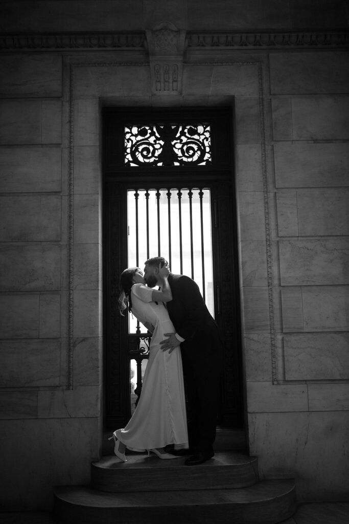 Black and white photo of a couple kissing during their New York Public Library engagement photos.