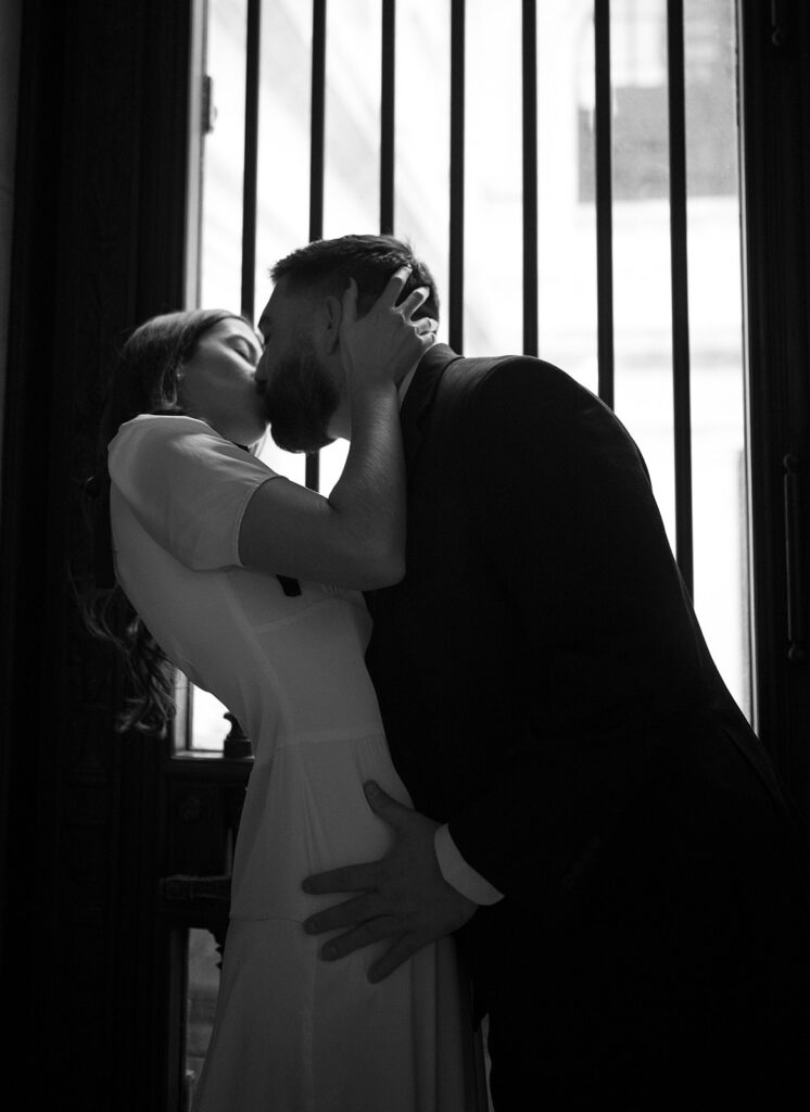 Close up black and white photo of a couple kissing.