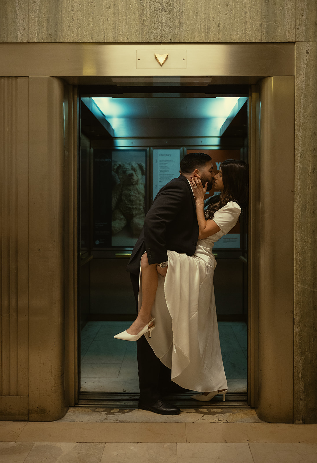 Couple kissing in the elevator for their New York Public Library engagement photos.