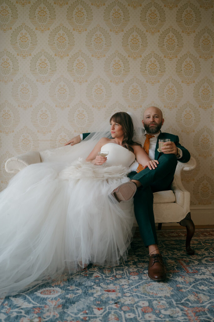 Bride and groom sitting in a couch in the Manor House at Stone Acres Farm.