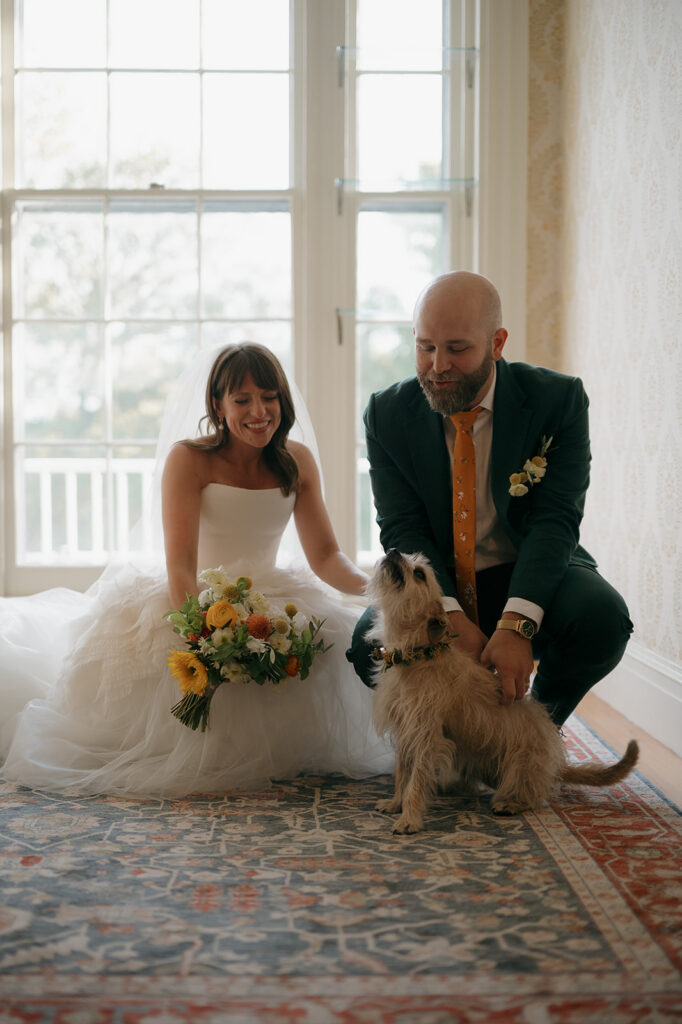 Bride and groom greeting their dog in the manor house at Stone Acres Farm. 