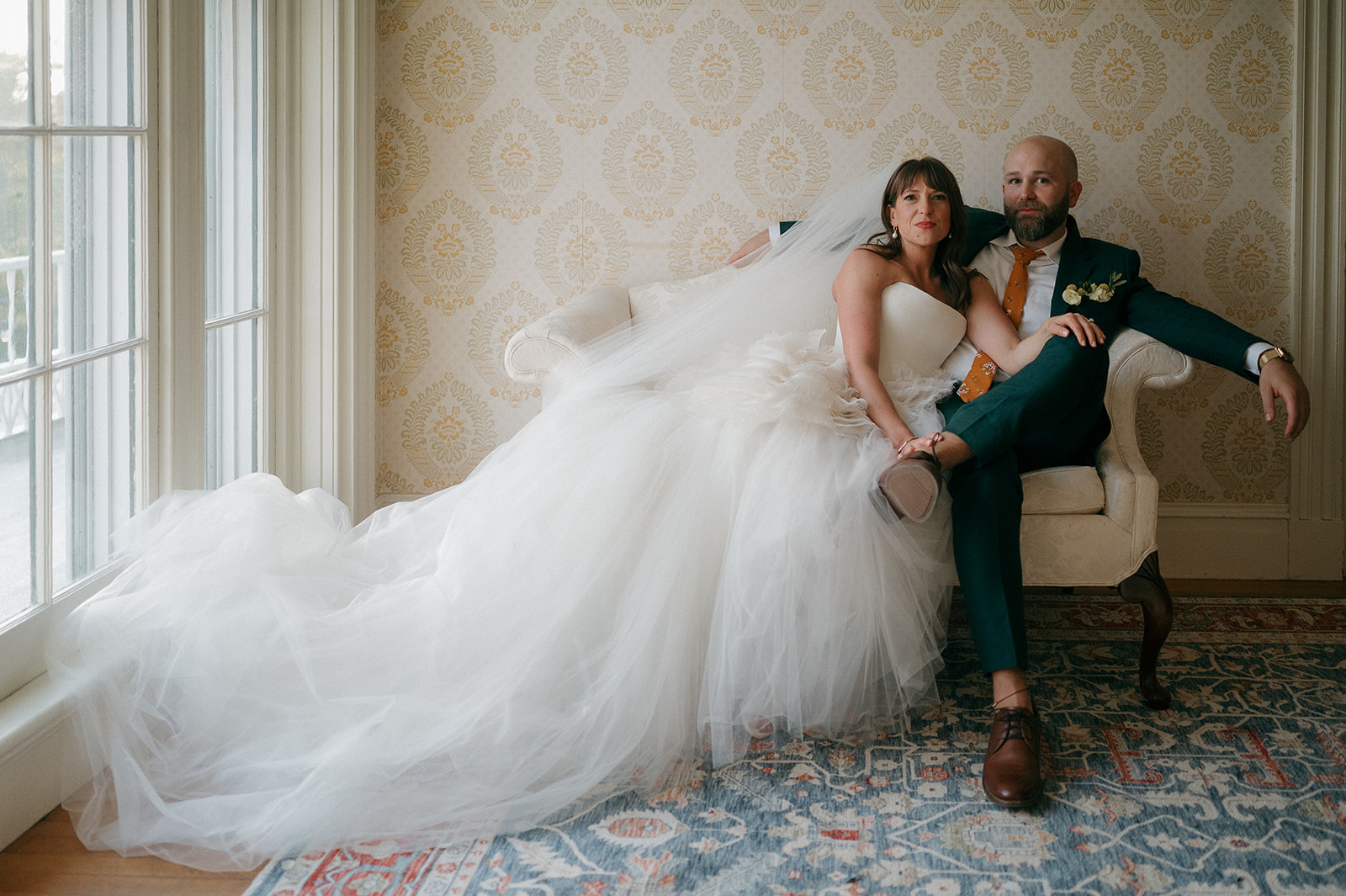 Bride and groom sitting in manor house room during Stone Acres Farm wedding portraits.