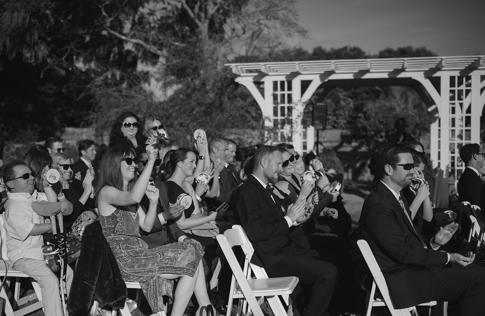Guests celebrating with tambourines during recessional at Stone Acres Farm Boxwood Garden ceremony.