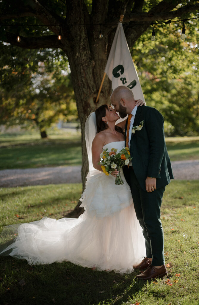 Bride and groom touching noses underneath a tree at Stone Acres Farm wedding venue. 