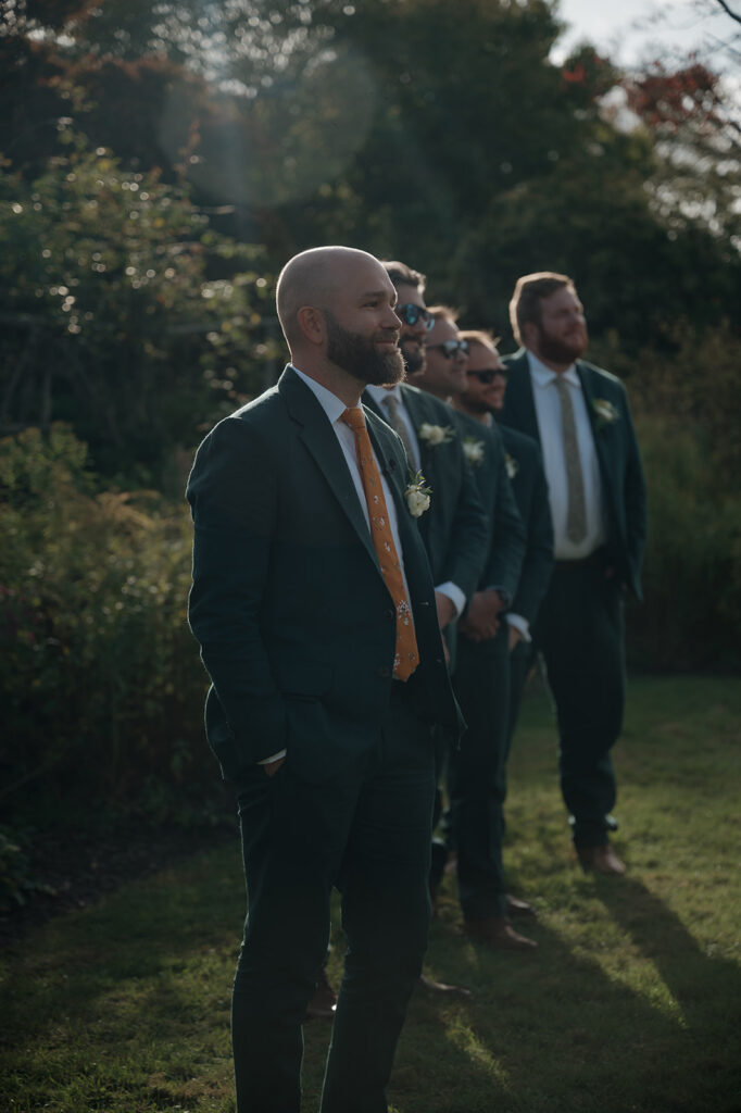Groom waiting with groomsmen in garden ceremony space at Stone Acres Farm wedding venue.