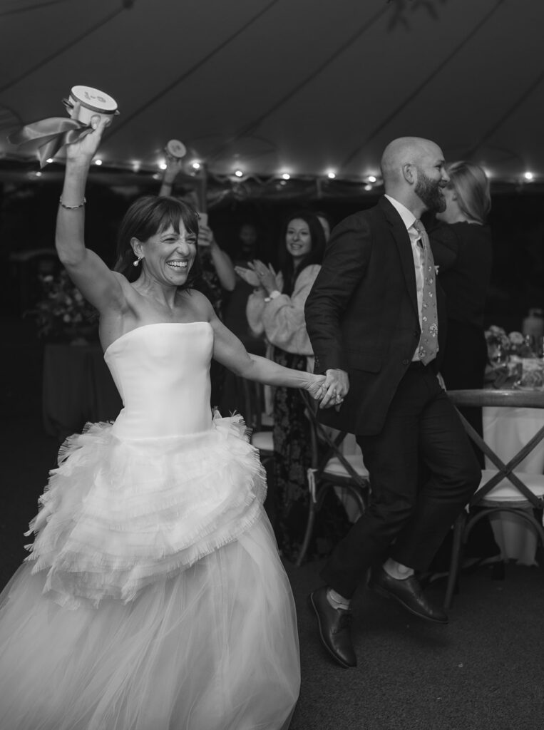Bride and groom entering tented reception space in The Meadow at Stone Acres Farm wedding in Connecticut.