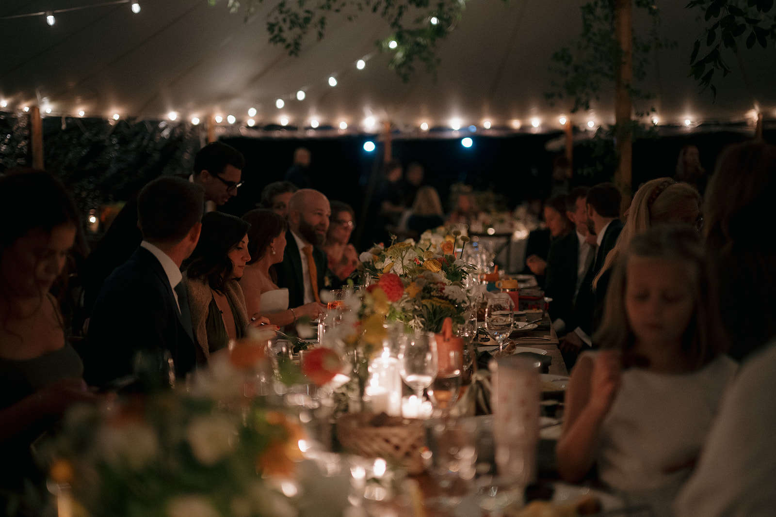 Candid wedding reception photo of guests having dinner and mingling. 