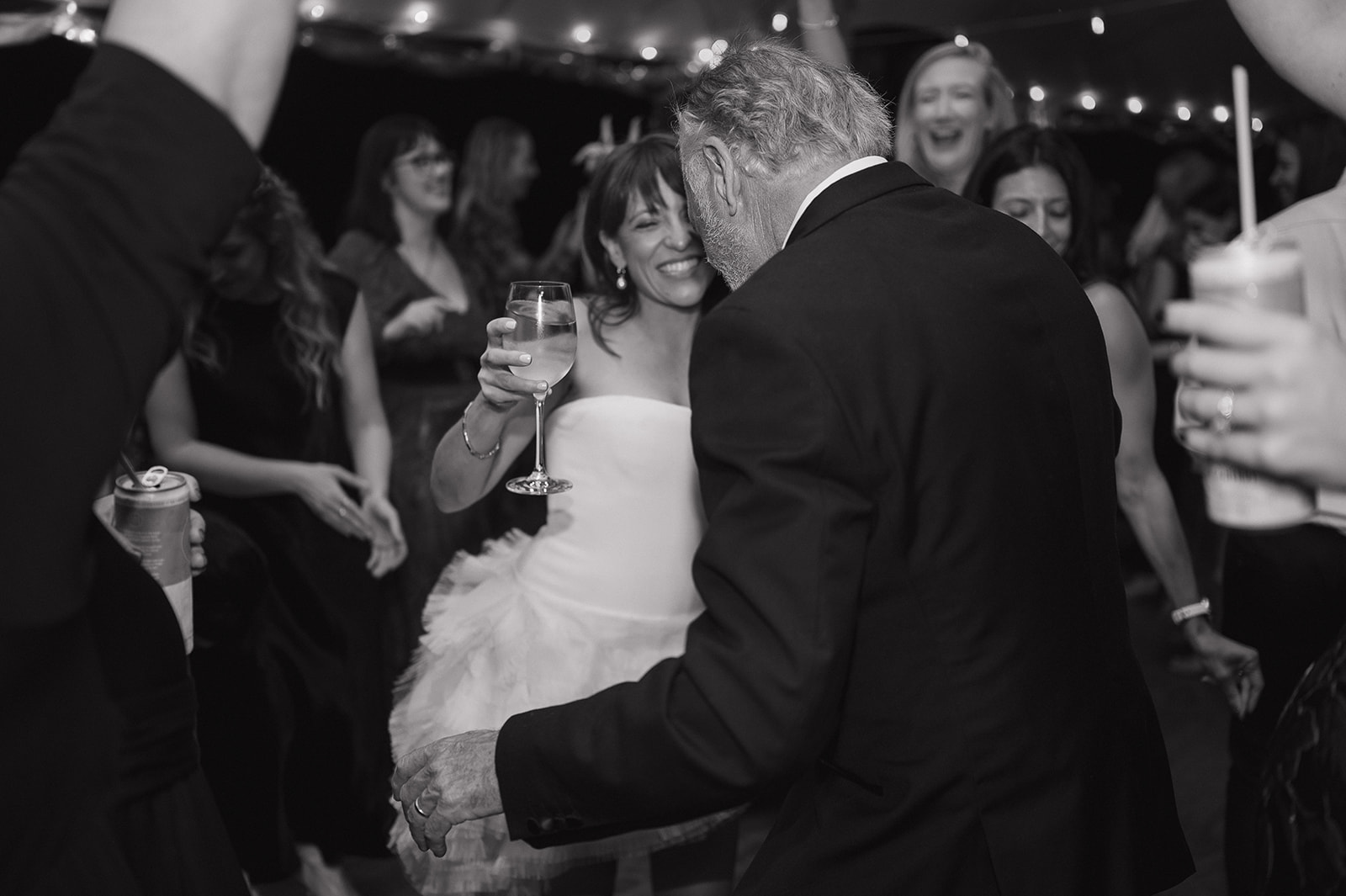 Black and white photo of a bride and guests dancing.