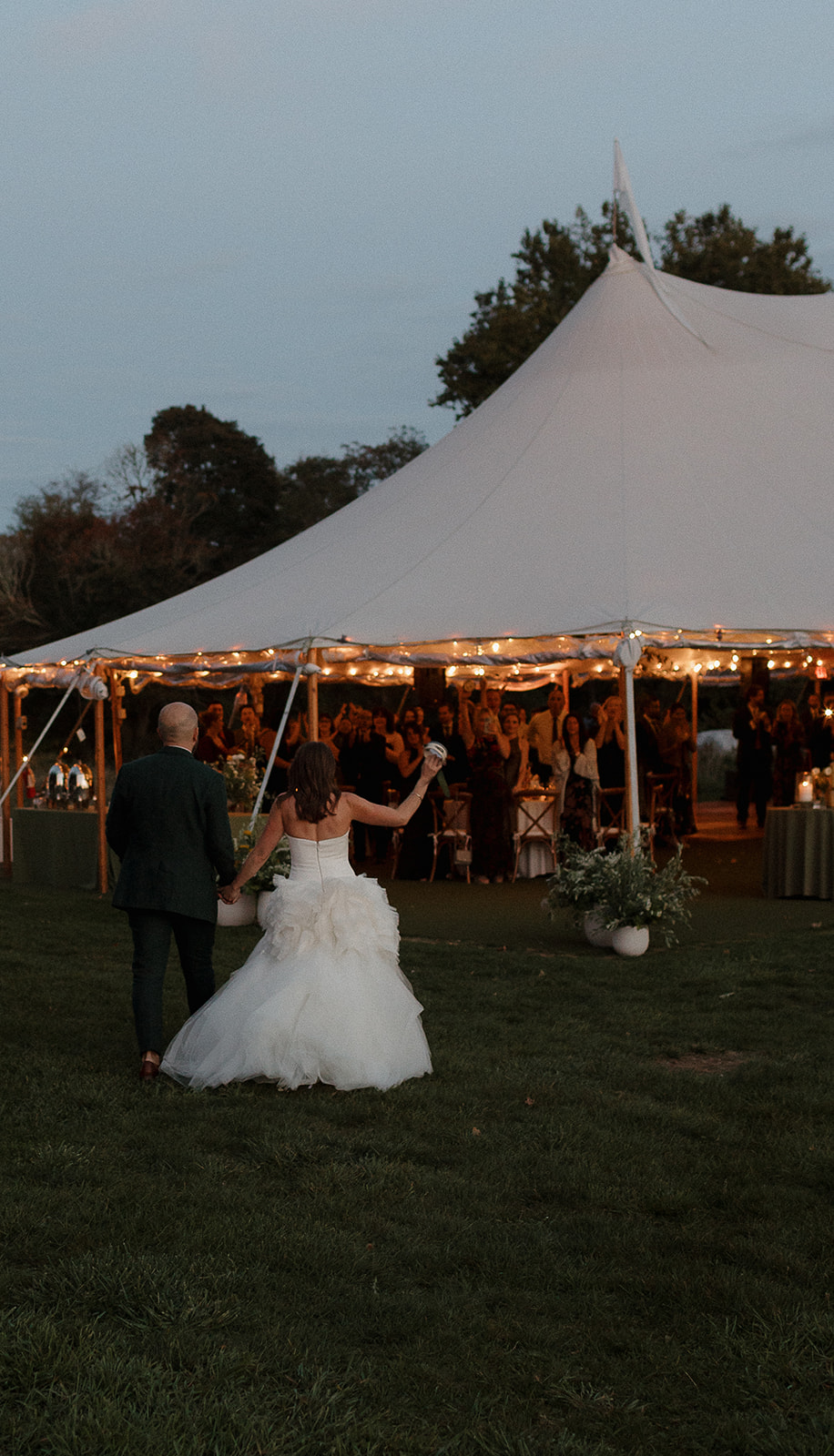 Bride and groom entering tented reception space in The Meadow at Stone Acres Farm wedding in Connecticut.