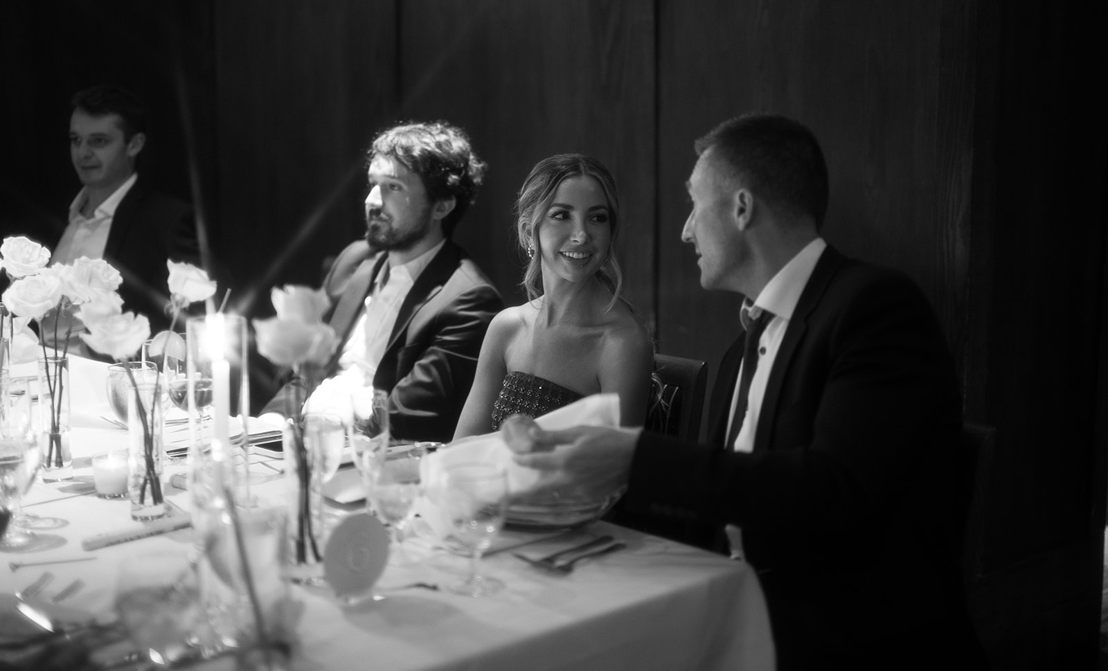 Black and white cinematic style wedding reception photo of guests mingling during the reception. 
